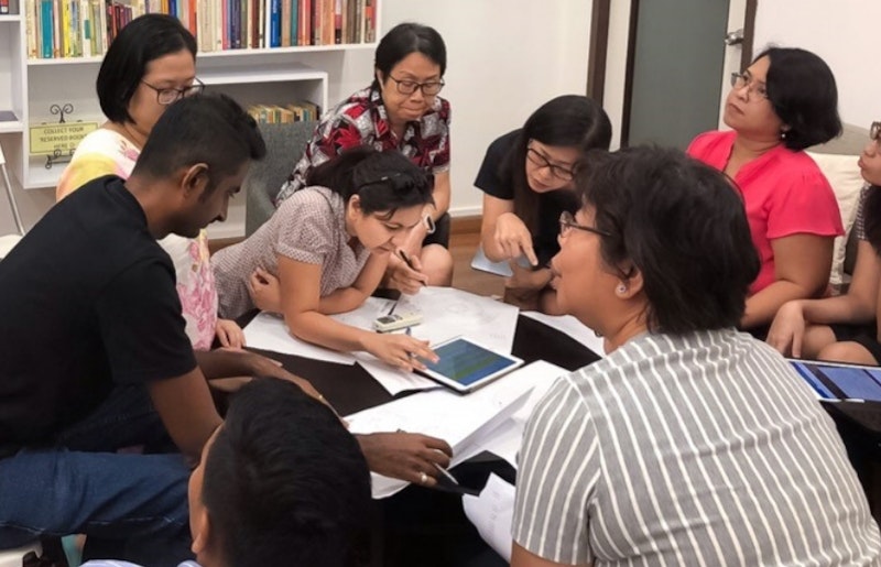 a circle of people studying the materials