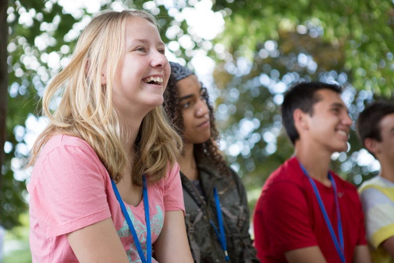 Four youth laughing together.